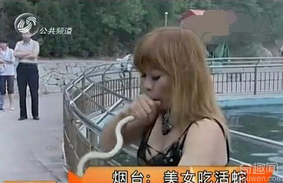 山东烟台景区内一美女正在进行吃活蛇表演