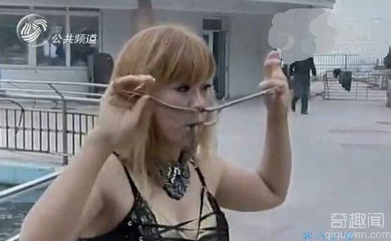 山东烟台景区内一美女正在进行吃活蛇表演